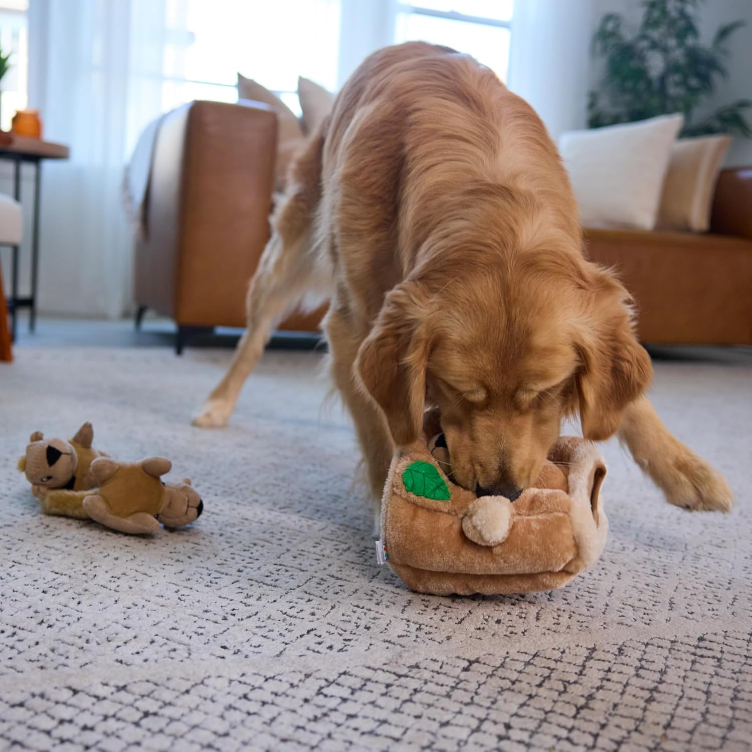 Dog pulling squirrel toys from plush tree trunk